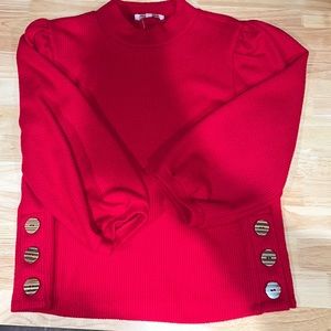 Red high neck 3/4 sleeve shirt. Detailed with buttons up the side
